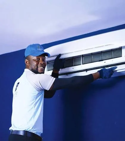 Illustrative technician checking a wall-mounted air-conditioning unit